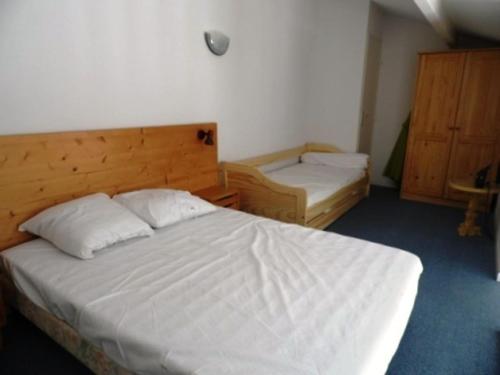 - une chambre avec un lit blanc et une tête de lit en bois dans l'établissement Maisonette avec Jardin Proche Plage et Piscine à La Faute-sur-Mer - FR-1-194-177, à La Faute-sur-Mer