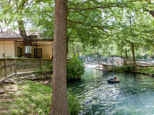 a person in a boat on a river with a bridge at The Resort at Schlitterbahn in New Braunfels