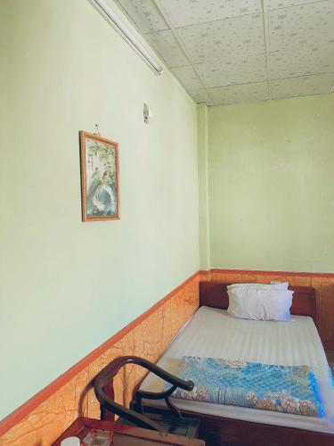 a small room with a bed and a chair at Nhà nghỉ FAMY in Móng Cái