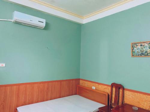 a room with a bed and a air conditioner on the wall at Nhà nghỉ FAMY in Móng Cái
