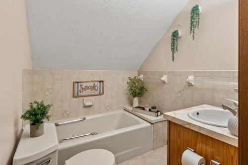 a bathroom with a tub and a sink at Deer Hollow by AvantStay Big Yard Lake Access in Albrightsville