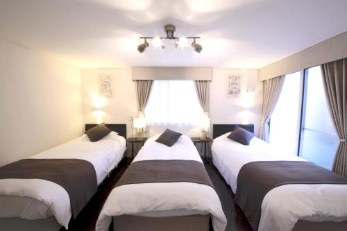 three beds in a room with windows at Urayasu Detached house UK1 in Tokyo
