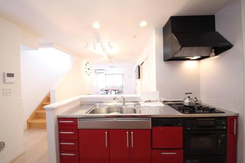 a kitchen with red cabinets and a sink at Urayasu Detached house UK1 in Tokyo