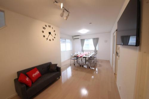 a living room with a couch and a clock on the wall at Urayasu Detached house UK1 in Tokyo