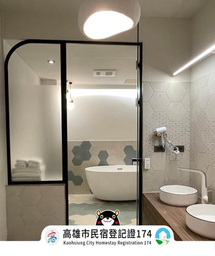a bathroom with a glass door with a tub and a toilet at Green Inn Kaohsiung in Kaohsiung