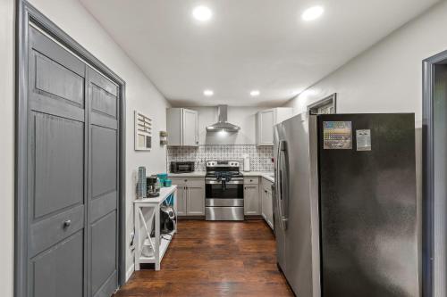a kitchen with white cabinets and a black refrigerator at The Tranquil Trails by AvantStay Lake Access Deck Fireplace in Albrightsville