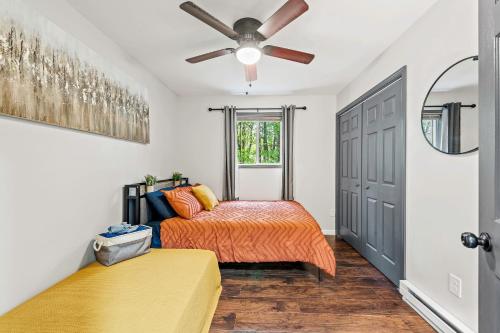 a bedroom with a bed and a ceiling fan at The Tranquil Trails by AvantStay Lake Access Deck Fireplace in Albrightsville