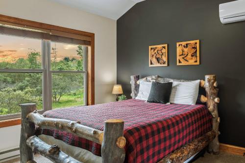 a bedroom with a bed with a large window at Otter Banks by AvantStay Sleeps 18 Hot Tub Views Game Room in Albrightsville