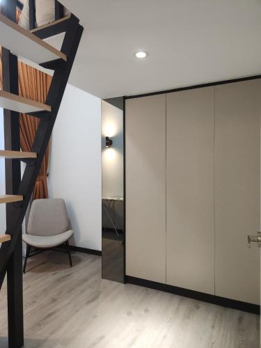 a room with white cabinets and a chair and a staircase at The Luxe By MySky Stays at Presint 5, Putrajaya in Putrajaya