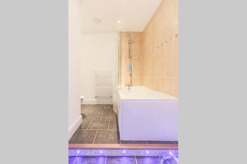 a bathroom with a tub and a sink at Tidemill House Apartment in Falmouth
