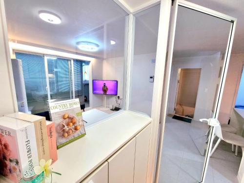 a room with a desk with books and a tv at 공간616 iksan in Pup'yŏng