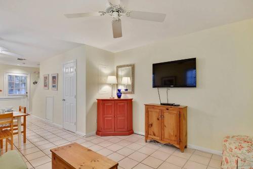 a living room with a flat screen tv on the wall at A Little Slice Of Paradise by AvantStay Communal Pool Screened in Porch Great Location Month Long Stays in Stock Island