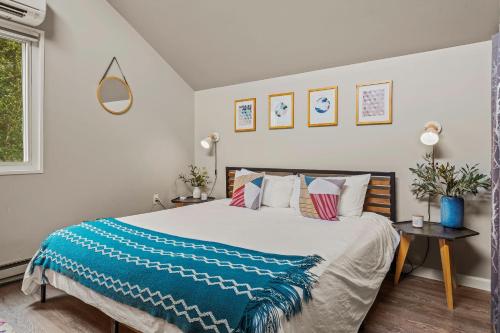 a bedroom with a large bed with a blue blanket at Inn the Poconos by AvantStay Private Lake Access Enclosed Hot Tub in Long Pond