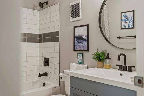 a bathroom with a sink and a toilet and a mirror at Inn the Poconos by AvantStay Private Lake Access Enclosed Hot Tub in Long Pond