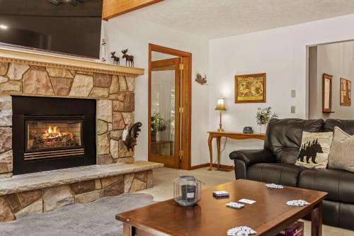 a living room with a couch and a fireplace at Tranquil Waterside by AvantStay Lakefront Dock Game Room Views in Pocono Summit