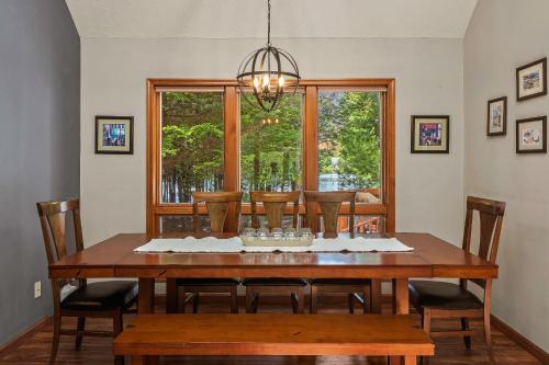 a dining room table with chairs and a large window at Tranquil Waterside by AvantStay Lakefront Dock Game Room Views in Pocono Summit