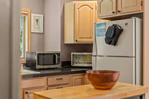 a kitchen with a refrigerator and a bowl on a table at Tranquil Waterside by AvantStay Lakefront Dock Game Room Views in Pocono Summit