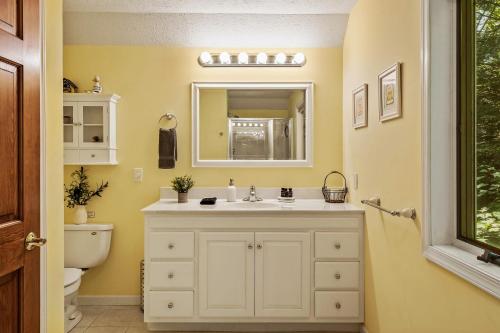 a bathroom with a sink and a toilet at Tranquil Waterside by AvantStay Lakefront Dock Game Room Views in Pocono Summit