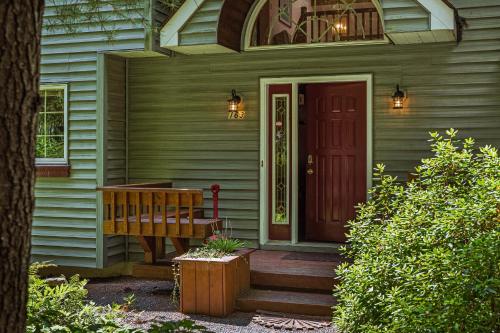 a porch of a house with a red door at Tranquil Waterside by AvantStay Lakefront Dock Game Room Views in Pocono Summit