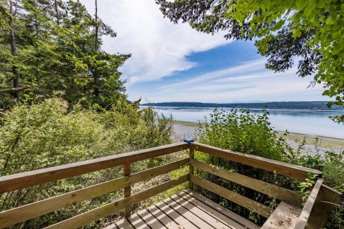 a wooden bench sitting next to a body of water at The Cottage at Herons Roost by AvantStay in Langley