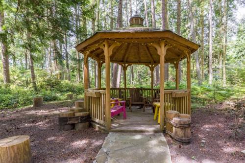a wooden gazebo in the middle of a forest at The Cottage at Herons Roost by AvantStay in Langley