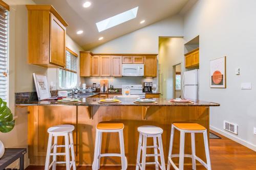 a kitchen with wooden cabinets and bar stools at The Cottage at Herons Roost by AvantStay in Langley