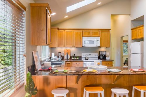 a kitchen with wooden cabinets and white appliances at The Cottage at Herons Roost by AvantStay in Langley