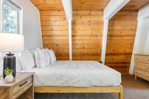 a bed in a room with a wooden wall at Chickaree by AvantStay A-Frame w Mountain Views in Tahoe City