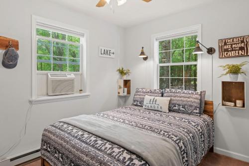 a bedroom with a bed and two windows at Ridge Retreat by AvantStay Game Room Covered Porch Fire Pit in Blakeslee