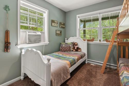 a childs bedroom with a white crib and windows at Ridge Retreat by AvantStay Game Room Covered Porch Fire Pit in Blakeslee