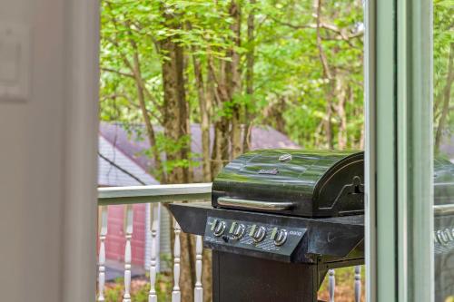 a grill sitting on a porch next to a window at Ridge Retreat by AvantStay Game Room Covered Porch Fire Pit in Blakeslee