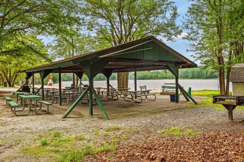 a picnic shelter with tables and benches next to a lake at Ridge Retreat by AvantStay Game Room Covered Porch Fire Pit in Blakeslee