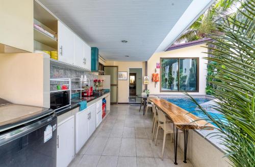 a kitchen with a table and a swimming pool at Cozy Asian house pool villa Pattaya 4 bedroom,Pet friendly in Jomtien Beach