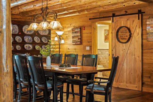 a dining room with a wooden table and chairs at The Bigwood Cabin by AvantStay Hot Tub Firepit Pool Table Private Yard in Long Pond