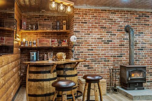 a bar with two stools and a brick wall at The Bigwood Cabin by AvantStay Hot Tub Firepit Pool Table Private Yard in Long Pond