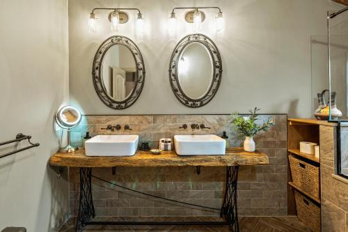 two sinks in a bathroom with mirrors on the wall at The Bigwood Cabin by AvantStay Hot Tub Firepit Pool Table Private Yard in Long Pond