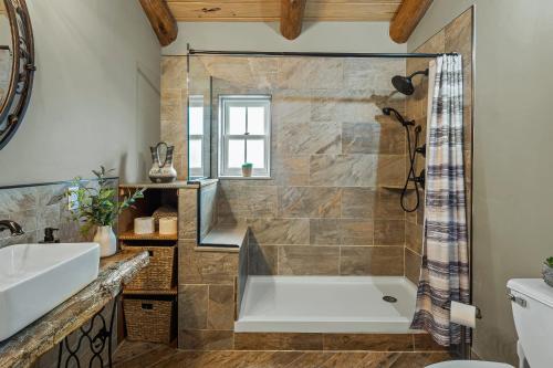 a bathroom with a tub and a sink at The Bigwood Cabin by AvantStay Hot Tub Firepit Pool Table Private Yard in Long Pond