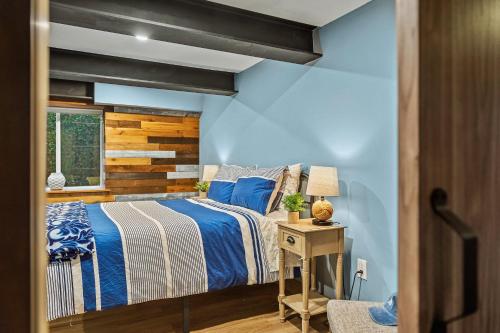 a bedroom with a bed and a wooden wall at The Bigwood Cabin by AvantStay Hot Tub Firepit Pool Table Private Yard in Long Pond