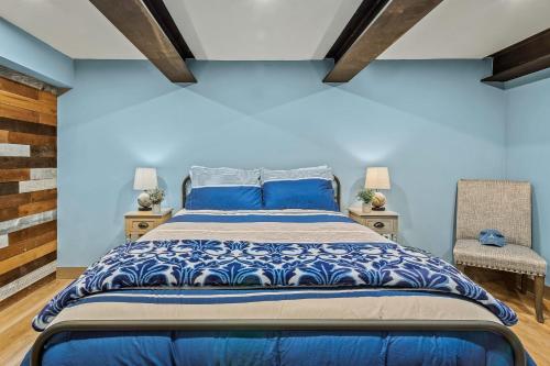 a bedroom with a large bed with blue walls at The Bigwood Cabin by AvantStay Hot Tub Firepit Pool Table Private Yard in Long Pond