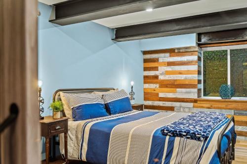 a bedroom with a bed and a wooden wall at The Bigwood Cabin by AvantStay Hot Tub Firepit Pool Table Private Yard in Long Pond