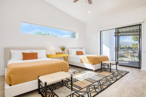 a white bedroom with two beds and a couch at Buena Vista by AvantStay Massive Outdoor Oasis w Pool Spa Firepit in La Quinta
