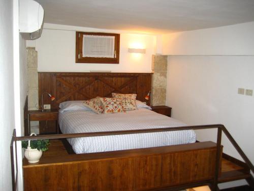 sypialnia z łóżkiem z drewnianym zagłówkiem w obiekcie Porta Borsari Suite Astori w Weronie