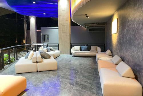 a room with couches and chairs on a balcony at Howard Johnson by Wyndham Pattaya JC in Na Jomtien