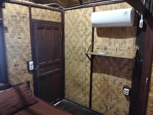 a small room with a toilet and a door at Villa panrangluhu in Bira