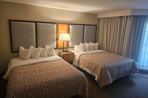 a hotel room with two beds and a lamp at Americinn by Wyndham Birch Run - Frankenmuth in Birch Run