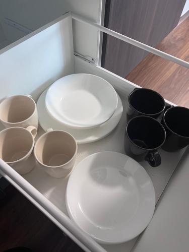 a drawer with white plates and black pots and pans at GUNPAKUMaebashi in Sōsha