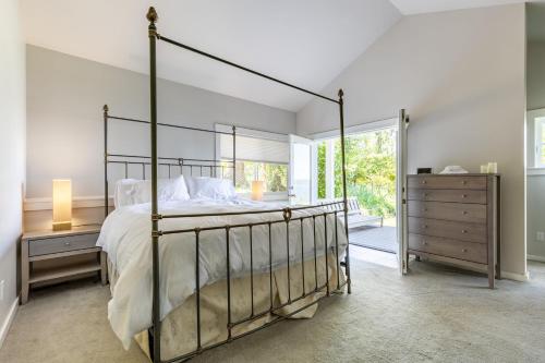 a bedroom with a canopy bed and a window at Langley by the Sea by AvantStay Panoramic Vistas in Langley