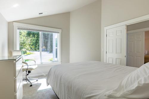 a white bedroom with a bed and a window at Langley by the Sea by AvantStay Panoramic Vistas in Langley