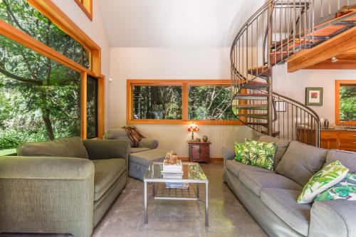 a living room with couches and a spiral staircase at Rhythm Waters by AvantStay Garden Paradise Pond in Langley