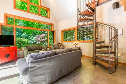 a living room with a couch and a spiral staircase at Rhythm Waters by AvantStay Garden Paradise Pond in Langley